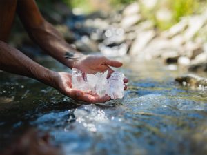Aaron K Metz tending to selenite crystals in The Nursery creek, using natural water currents for polishing