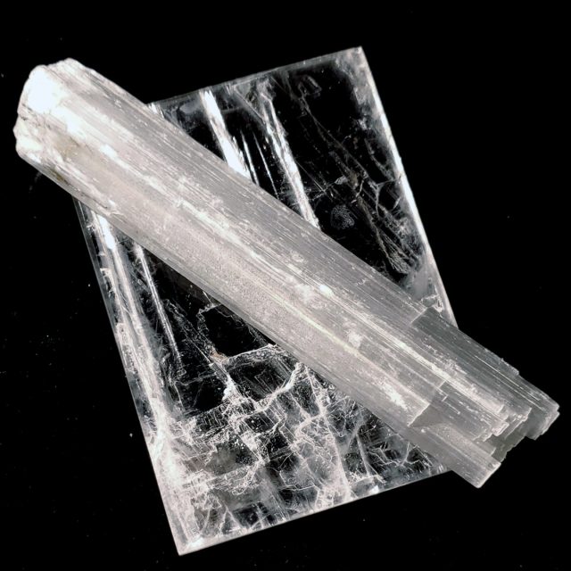 Comparison of clear selenite ice crystal next to fibrous satin spar crystal showing distinct structural differences